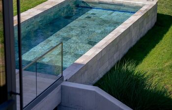 Piscina privata in Germania con Silberquarzit, pietra naturale di Grünig Natursteine, foto: B&B Fliesen, www.zollhalle.de